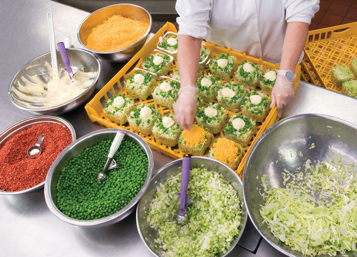 A chef preparing a freshly made dish with all sorts of ingredients freshly prepared